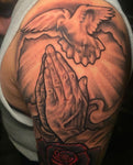Bold coverup tattoo with praying hands and dove.